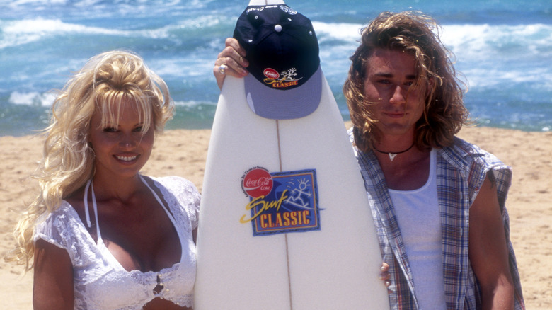 Pamela Anderson posing with costar Jason Simmons on a beach