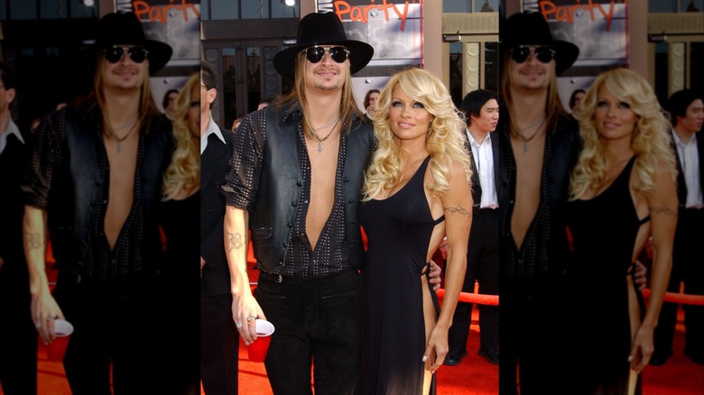 Pamela Anderson with long voluminous blond curls and posing with Kid Rock