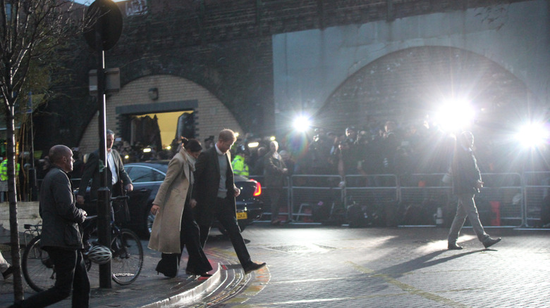 Harry and Meghan being photographed by paparazzi in London in 2018