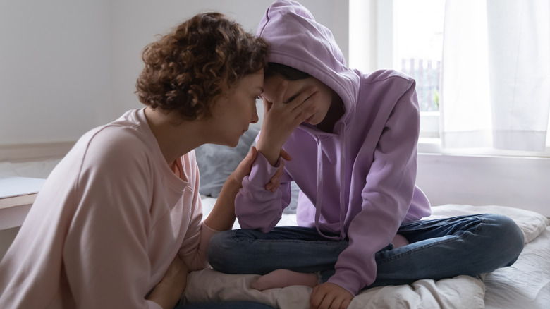 Woman comforting her teen daughter