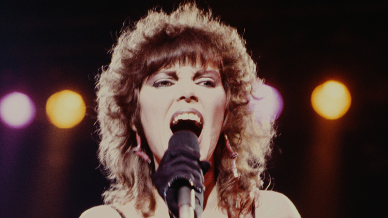 Pat Benatar singing into a microphone on stage