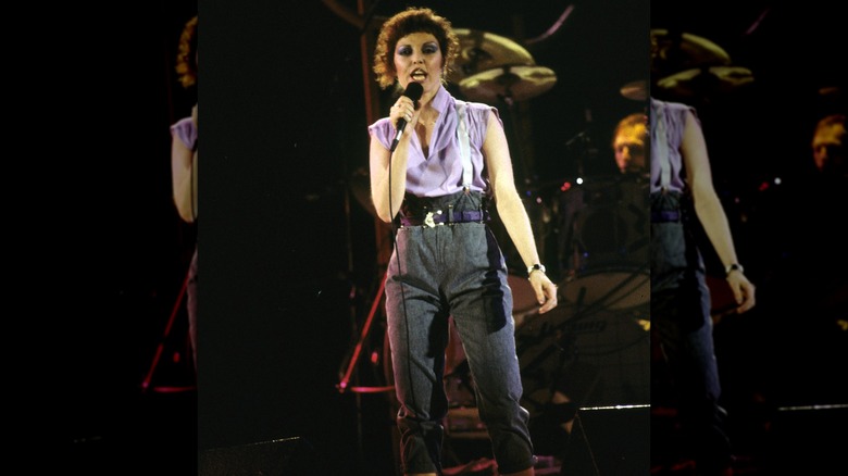 Pat Benatar singing into a microphone on stage