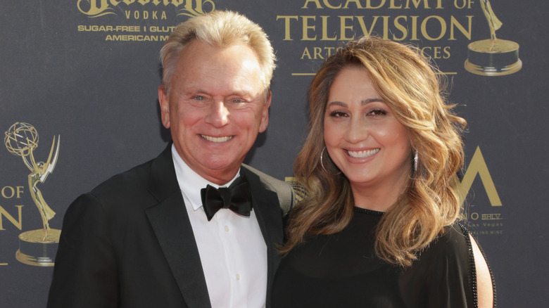 Pat Sajak and Lesly Brown posing and smiling together.