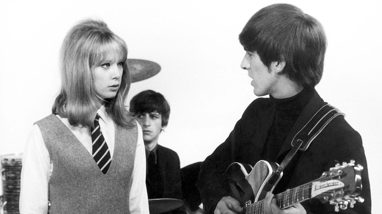Black-and-white photo of Pattie Boyd talking to George Harrison while Ringo Starr sits in the background