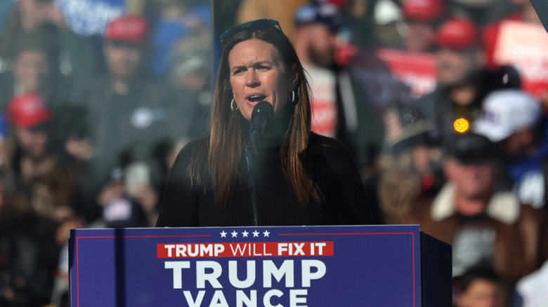 Sarah Huckabee Sanders giving a speech with sunglasses on her head