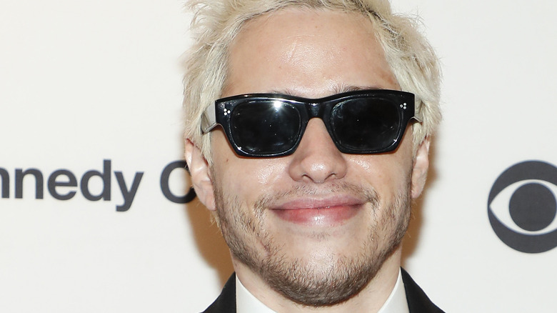 Pete Davidson smiles wearing sunglasses