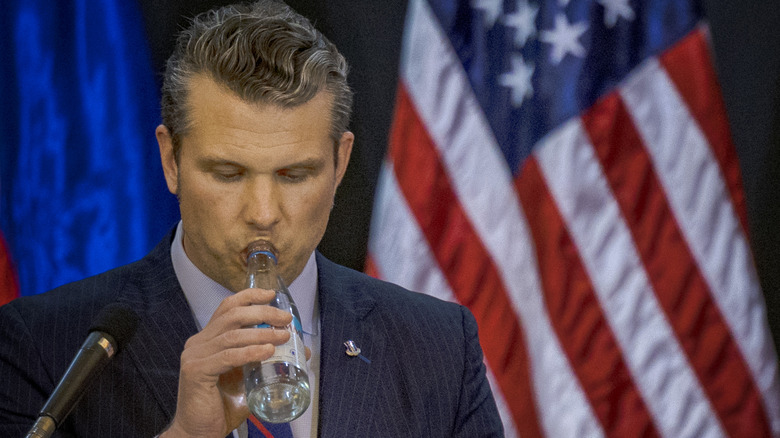 U.S. Defense Secretary Pete Hegseth drinks a bottle of water as Philippine Defense Secretary Gilbert Teodoro (not pictured) speaks during his visit at Camp Aguinaldo on March 28, 2025 in Quezon city, Metro Manila, Philippines.