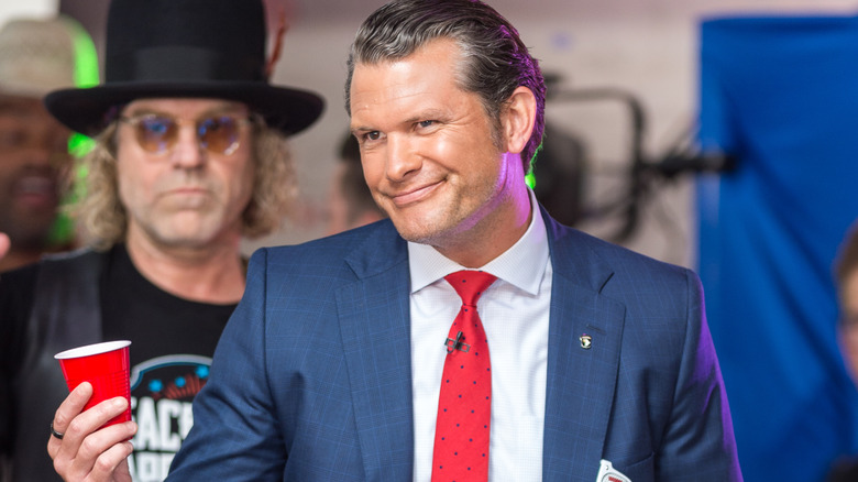 Pete Hegseth holding a red solo cup on stage for a "Fox & Friends" event