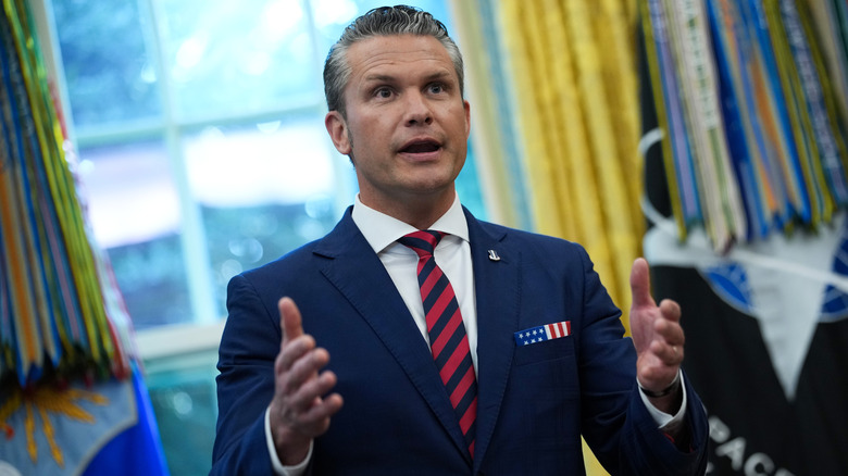 Pete Hegseth addressing reporters with both hands out