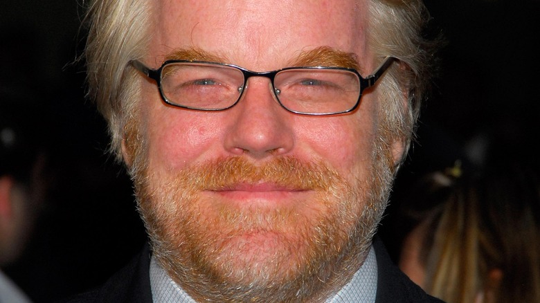 Philip Seymour Hoffman smiles wearing glasses