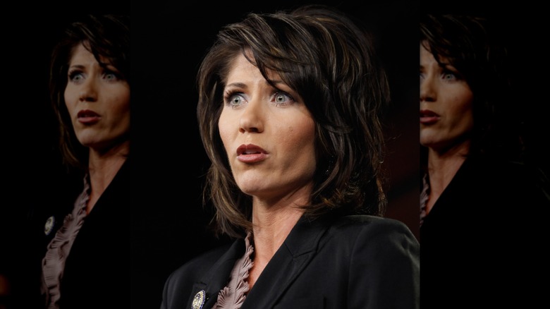 Kristi Noem form a lower angle in a black blazer.