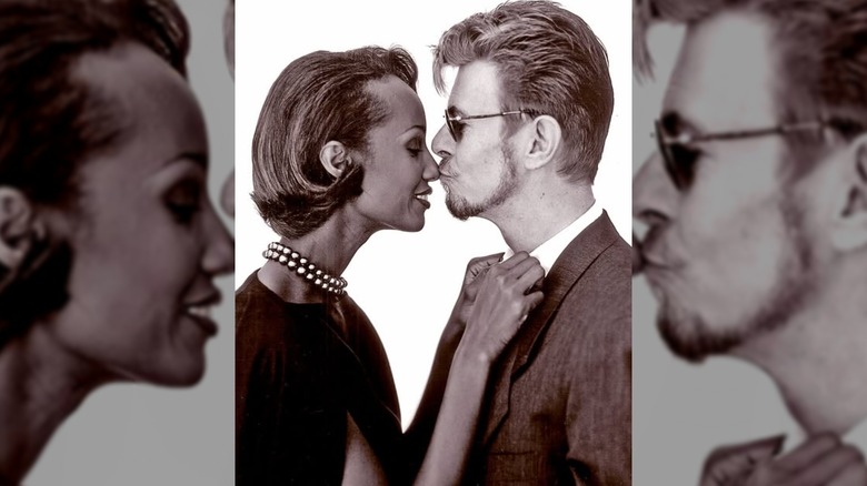 David Bowie kissing Iman on the nose as she fixes his shirt collar.