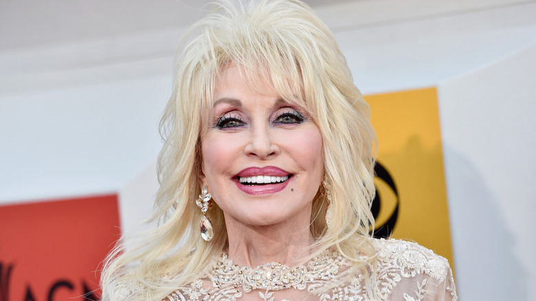 Dolly Parton smiling brightly and posing at an event.