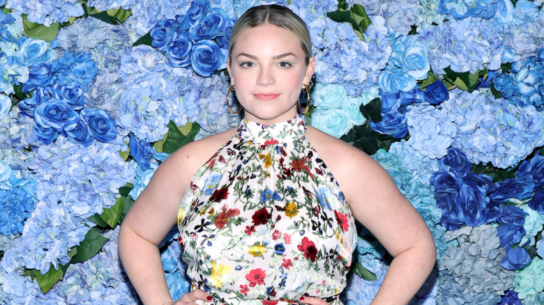 Ella Stiller posing in front of blue flower wall