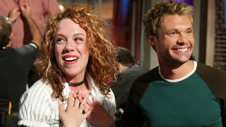 A woman next to Ryan Seacrest wearing a green shirt with blond, spiked hair
