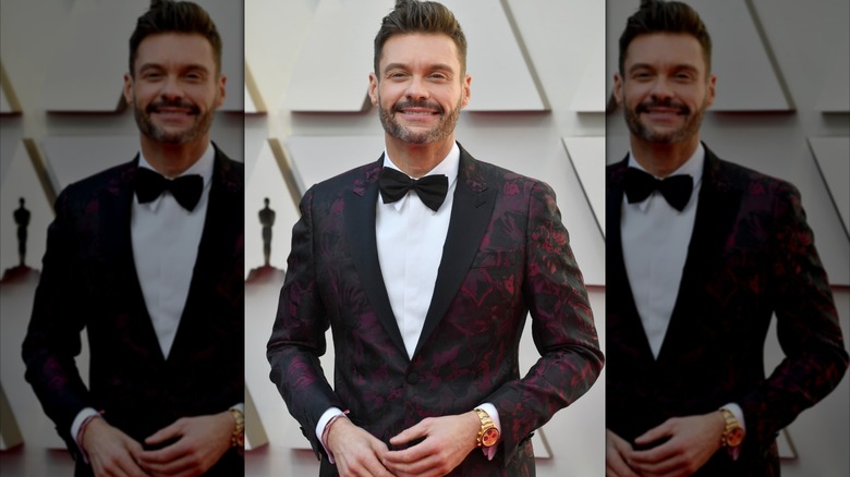 Ryan Seacrest wearing a red and black marble suit and tux is 2019