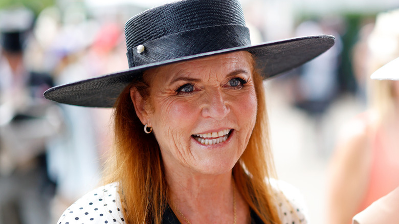 A smiling Sarah Ferguson wearing a big black hat and a white polka dot dress