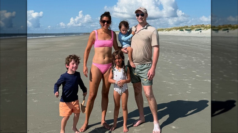 Stephen and Katie Miller posing with their kids on the beach
