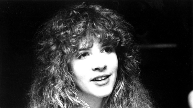 Stevie Nicks in a black and white photograph circa 1974, her hair permed and voluminous