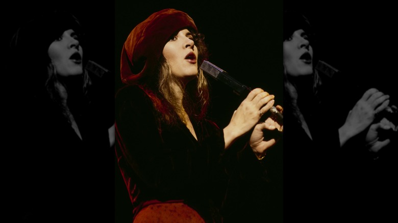 Stevie Nicks performing in New York City, in 1979, wearing a red hat and red velvet dress