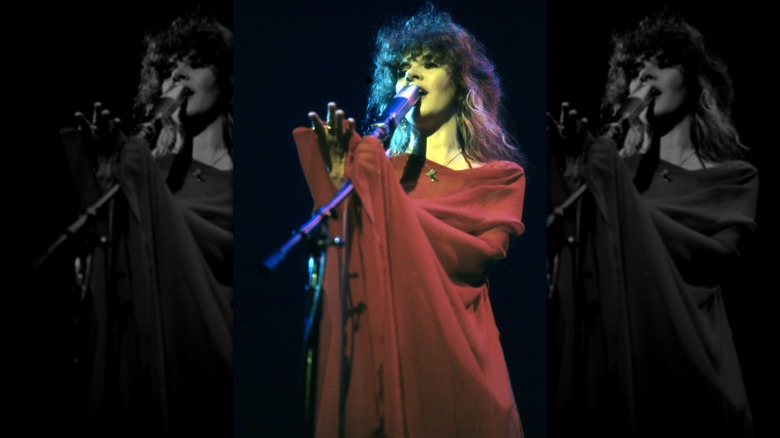 Stevie Nicks performing in 1979, singing with her eyes closed and wearing a red wrap
