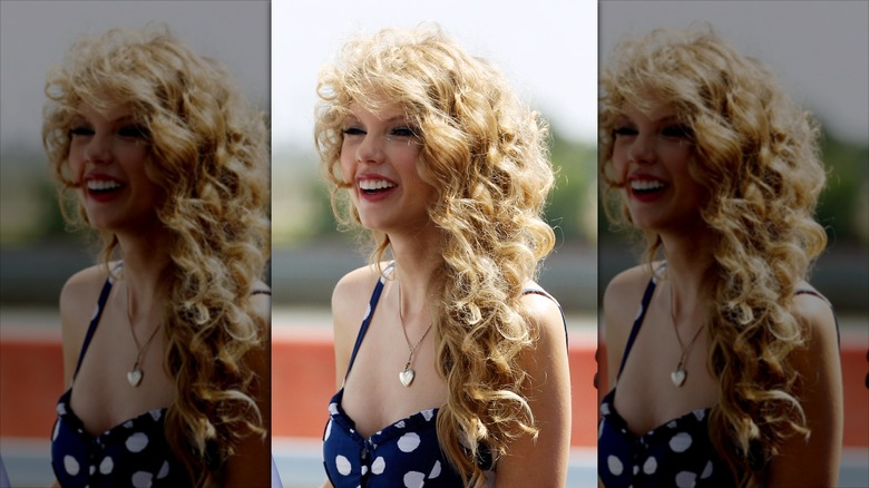 Side profile of Taylor Swift in a polka dot dress, mouth open in a smile.