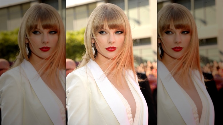 Taylor Swift with straightened hair in a white suit.
