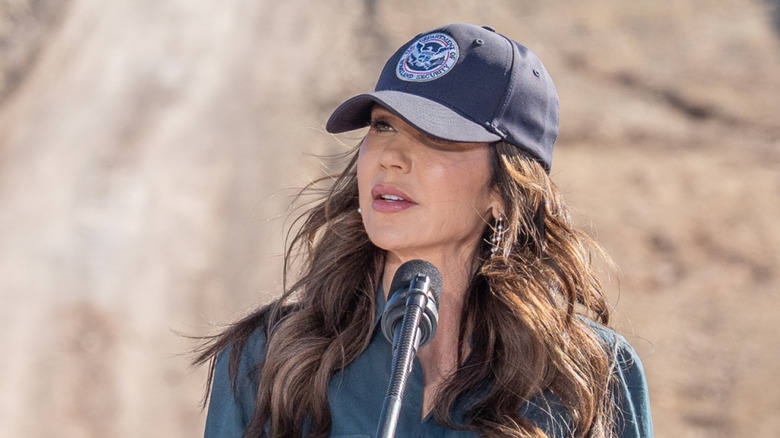 Kristi Noem at a conference with a baseball cap on