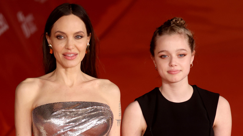 Angelina Jolie and daughter Shiloh standing shoulder to shoulder