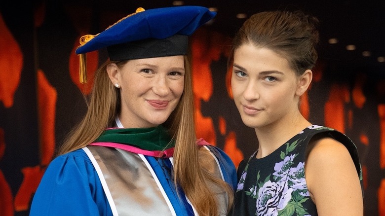 Jennifer Gates in a graduation cap and gown and Phoebe Gates in a floral dress