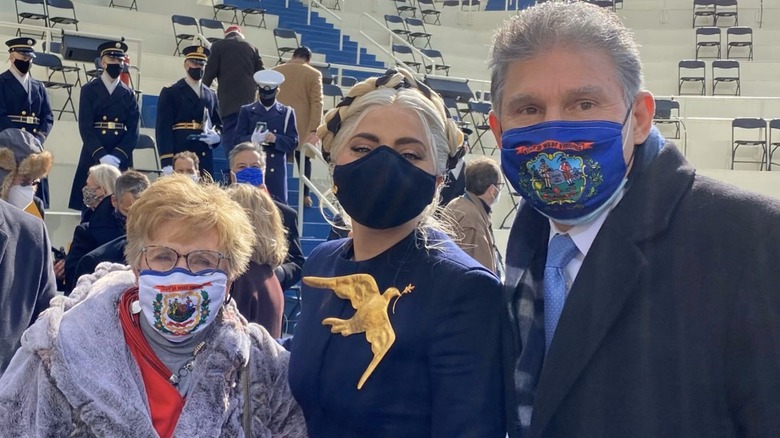 Lady Gaga poses with Joe Manchin at the 2021 inauguration. Because of the COVID-19 pandemic, they are wearing face masks.