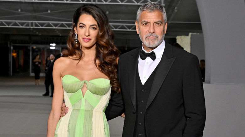 Amal Clooney and George Clooney posing at event