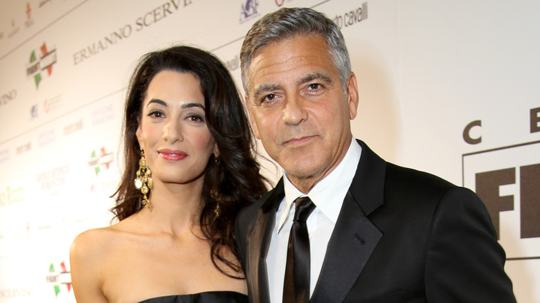 George Clooney and Amal Alamuddin posing at event