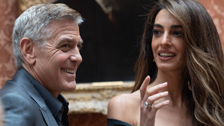 Amal Clooney and George Clooney laughing at event