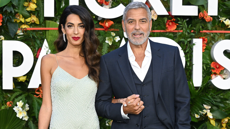 Amal Clooney and George Clooney posing at event
