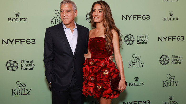 Amal Clooney and George Clooney posing at event
