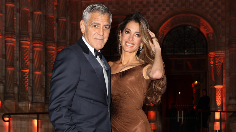 Amal Clooney and George Clooney posing at event