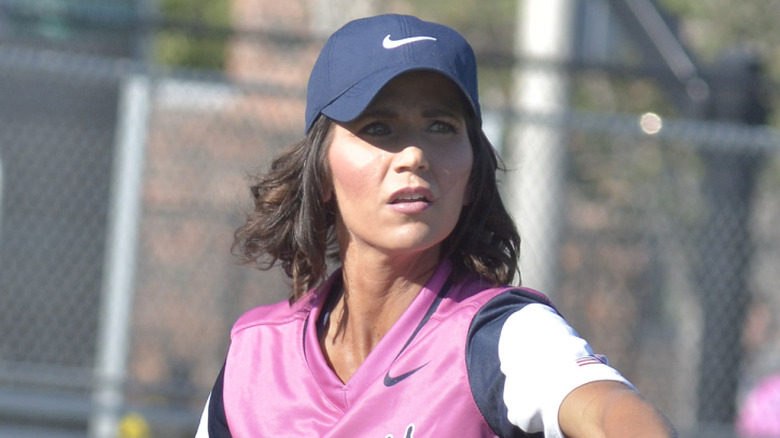 Kristi Noem playing softball in a pink shirt.