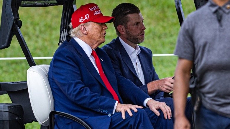 Donald Trump and Eric Trump drive in a golf cart at the LIV Golf Miami in Doral, FL (2025)