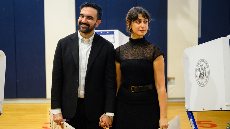 Zohran Mamdani smiling while holding Rama Duwaji's hand