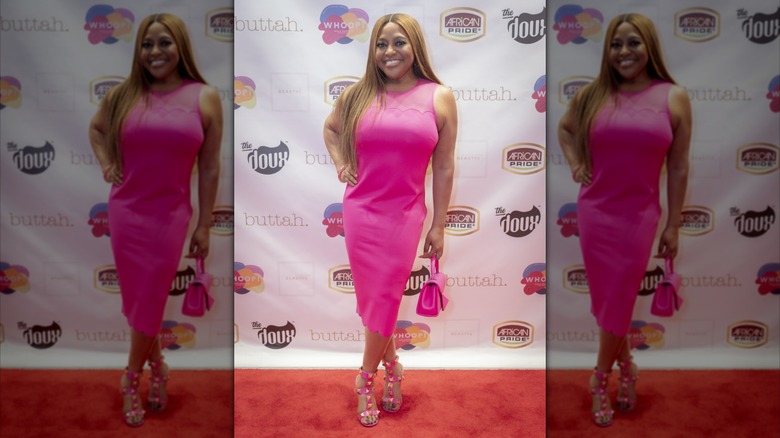 Sherri Shepherd grinning and posing in pink dress