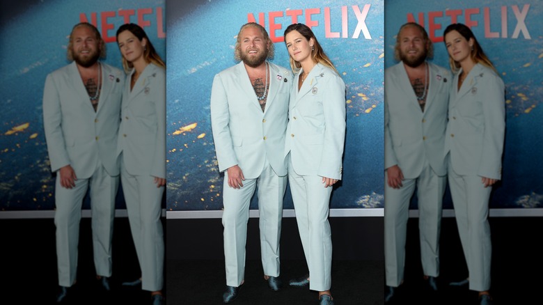 (l-r): Jonah Hill and Sarah Brady standing and posing together on the red carpet.