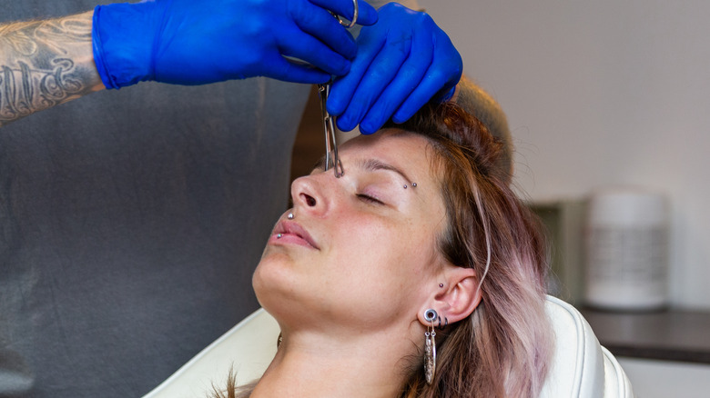 Woman getting pierced 