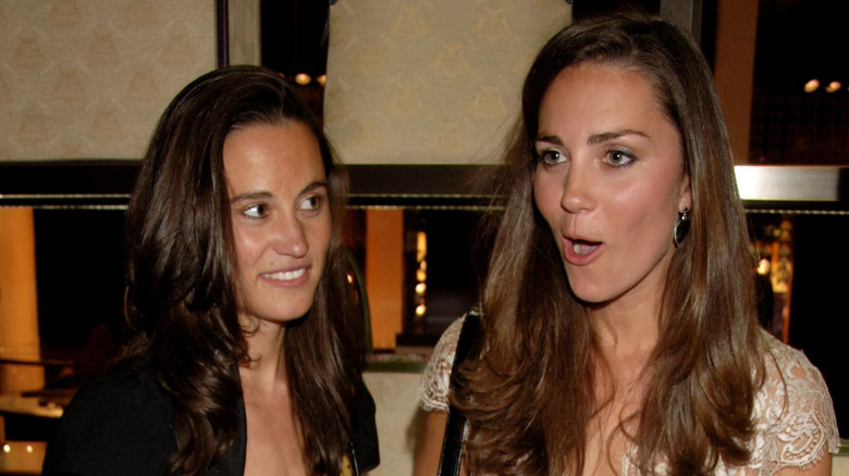 Pippa Middleton looking askance while Kate Middleton looks surprised