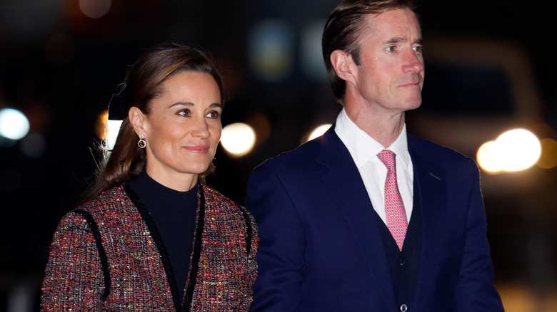 Pippa Middleton wearing a coat and James Matthews wearing a suit
