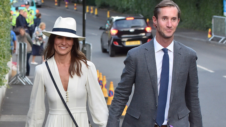 Pippa Middleton and James Matthews holding hands and smiling while walking together