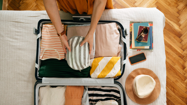 Suitcase with summertime clothing and hat