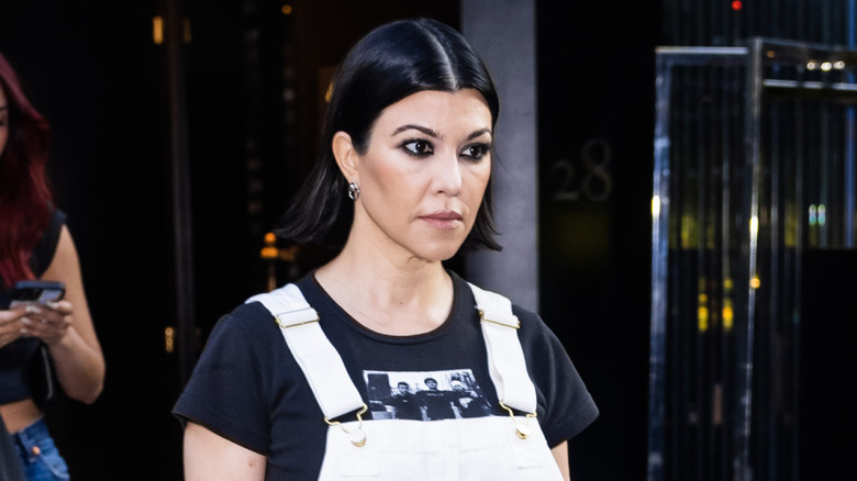 Kourtney Kardashian Barker in white overalls walking in New York City