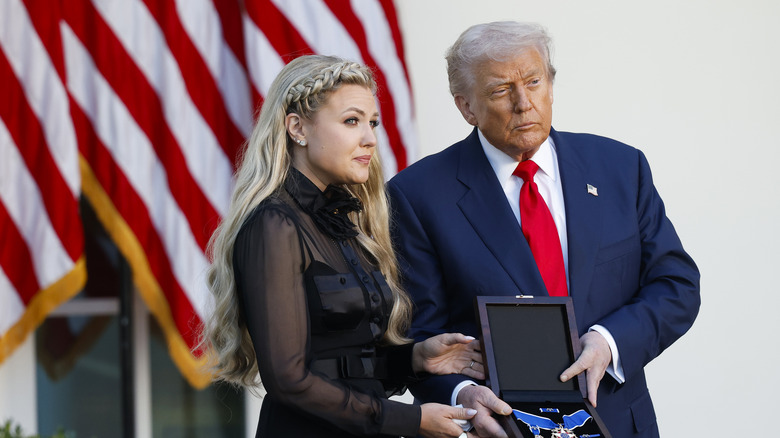 Erika Kirk and Donald Trump holding a medal