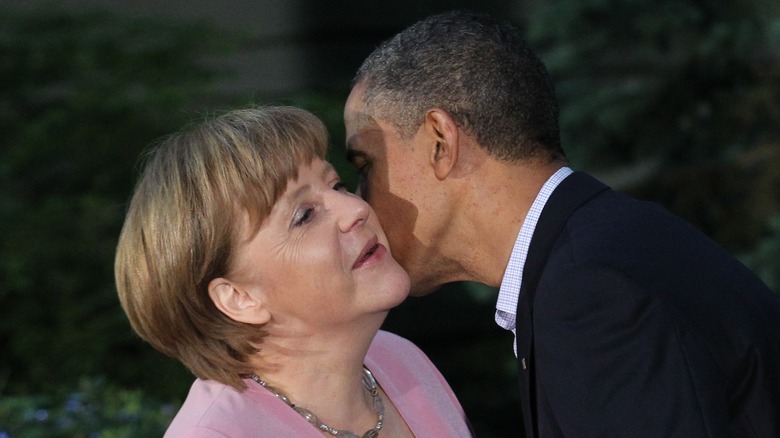 Angela Merkel receiving a kiss from Barack Obama